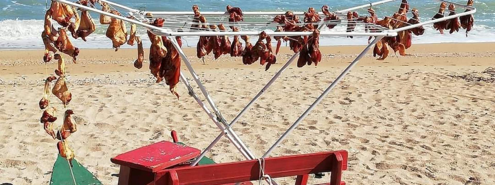 Marche, carne di pollo messa ad essiccare in spiaggia